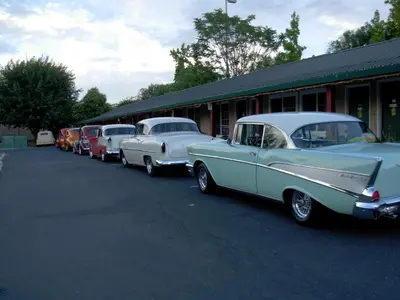 a row of old cars parked in a parking lot at Jumping Frog Motel in Angels Camp