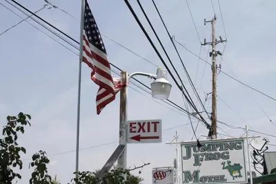 an american flag hanging from a street light at Jumping Frog Motel in Angels Camp