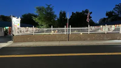 a white picket fence on the side of a street at Jumping Frog Motel in Angels Camp