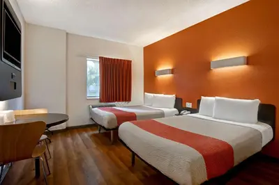 a hotel room with two beds and a desk at Motel 6-Gilroy, CA in Gilroy