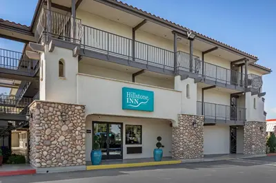 a building with a blue sign on the side of it at Hillstone Inn Tulare, an Ascend Collection Hotel in Tulare