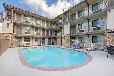 a swimming pool in front of a building with a hotel at Hillstone Inn Tulare, an Ascend Collection Hotel in Tulare