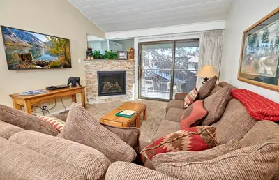 a living room with two couches and a fireplace at Austria Hof Lodge in Mammoth Lakes