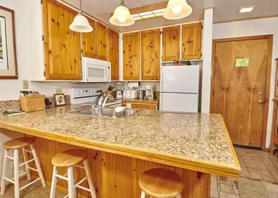 a kitchen with wooden cabinets and a counter top at Austria Hof Lodge in Mammoth Lakes