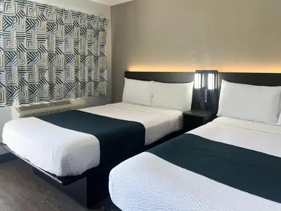 a hotel room with two beds with white and blue sheets at Motel 6-Tulare, CA in Tulare