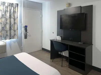 a hotel room with a desk and a television at Motel 6-Tulare, CA in Tulare