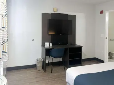 a bedroom with a desk with a television and a bed at Motel 6-Tulare, CA in Tulare