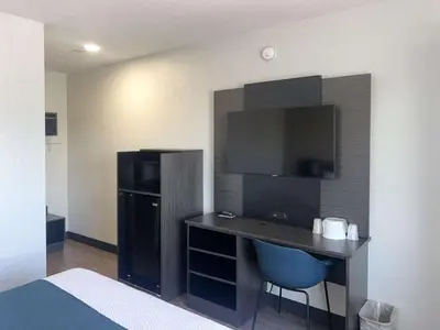 a hotel room with a desk and a refrigerator at Motel 6-Tulare, CA in Tulare