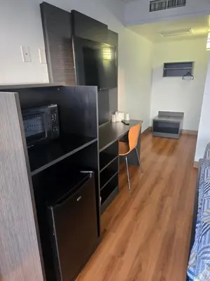 a small room with a desk and a microwave at Super 8 by Wyndham Tracy in Tracy