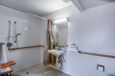 a white bathroom with a sink and a shower at Super 8 by Wyndham Tracy in Tracy