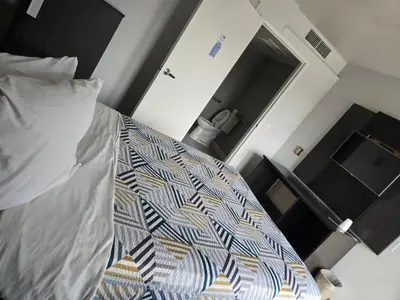 a bedroom with a bed with a colorful comforter at Super 8 by Wyndham Tracy in Tracy