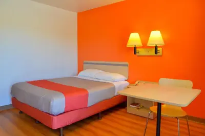 a small room with a bed and a table at Motel 6 - Santa Nella, on i-5 in Santa Nella Village