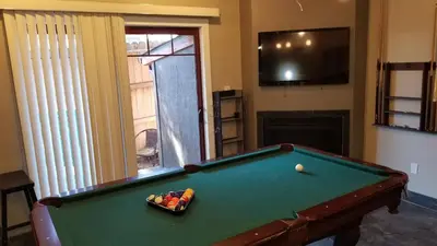 a living room with a pool table and a television at Gondola Lodge & Tahoe Beach Club in South Lake Tahoe