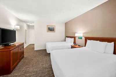 a hotel room with two beds and a flat screen tv at Best Western Stagecoach Inn in Pollock Pines