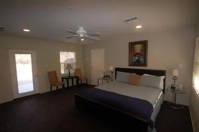 a bedroom with a bed and a ceiling fan at Queen's Inn By The River in Oakhurst