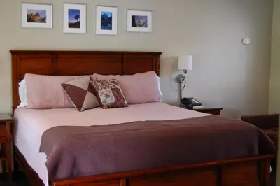 a bedroom with a large bed with pillows at Queen's Inn By The River in Oakhurst