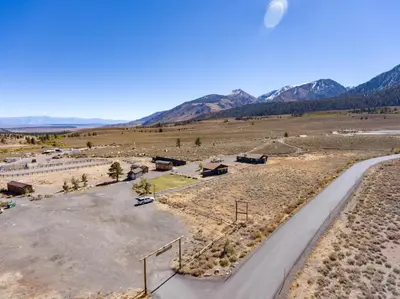 a road in a field with mountains in the background at Sierra Meadows Ranch in Mammoth Lakes