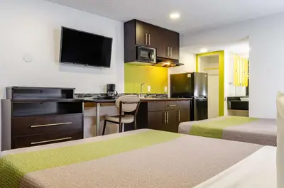 a small hotel room with two beds and a kitchen at Studio 6-Fresno, CA - Extended Stay in Pinedale