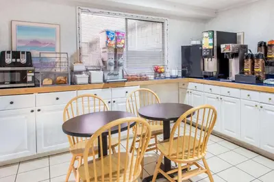 a kitchen with two tables and chairs in a kitchen at Super 8 by Wyndham Bishop in Bishop