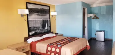 a hotel room with a bed and a picture on the wall at Super 8 by Wyndham Bishop in Bishop