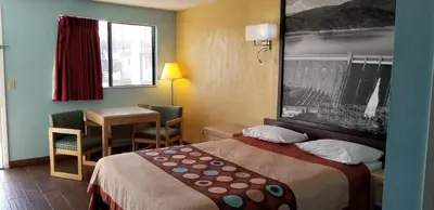 a small hotel room with a bed and a table at Super 8 by Wyndham Bishop in Bishop