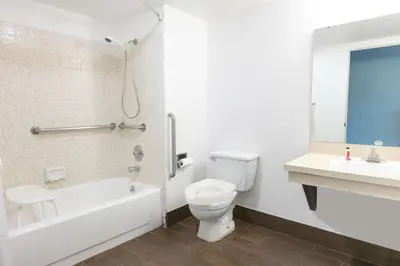 a bathroom with a toilet and a tub and a sink at Super 8 by Wyndham Bishop in Bishop