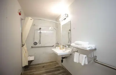 a bathroom with a shower and a sink and a mirror at Motel 6-Sacramento, CA - Central in Sacramento