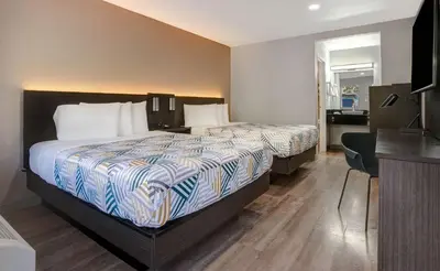a hotel room with two beds and a desk at Motel 6-Rancho Cordova, CA - Rancho Cordova East in Rancho Cordova