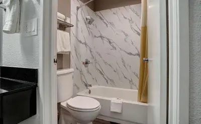 a bathroom with a toilet and a tub and a sink at Motel 6-Rancho Cordova, CA - Rancho Cordova East in Rancho Cordova