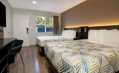 a hotel room with two beds and a desk at Motel 6-Rancho Cordova, CA - Rancho Cordova East in Rancho Cordova