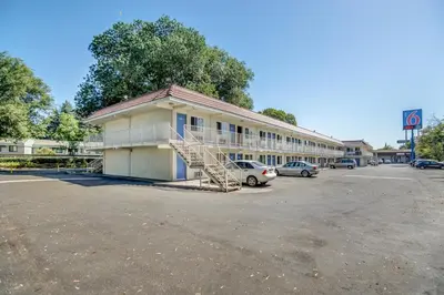 a building with a car parked in a parking lot at Motel 6-Stockton, CA - North in Lincoln Village