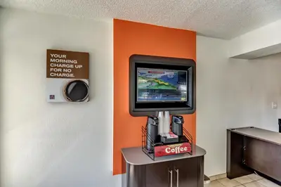 a video game console in a room with an orange wall at Motel 6-Stockton, CA - North in Lincoln Village