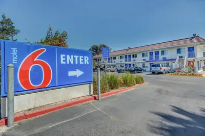 a sign in a parking lot next to a street at Motel 6-Stockton, CA - Charter Way West in Stockton