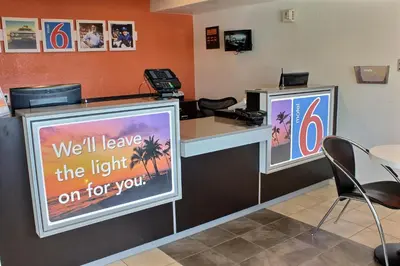 a reception desk with a sign that says well leave the light on for you at Motel 6-Coalinga, CA - East in Coalinga