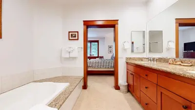 a bathroom with a tub and a sink and a mirror at Timbers 5 4-Bedroom Townhouse Townhouse in Mammoth Lakes