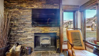 a stone fireplace with a television on top of it at Snowcreek 269 Condo in Mammoth Lakes