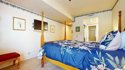 a bedroom with a bed with a blue comforter at Silver Bear 18 Condo in Mammoth Lakes