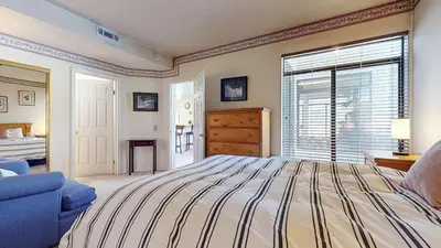 a large bedroom with a bed and a blue chair at Silver Bear 18 Condo in Mammoth Lakes
