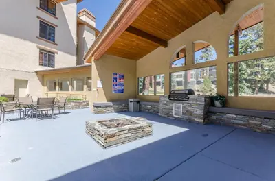a patio with a fire pit in the middle of a building at Silver Bear 18 Condo in Mammoth Lakes