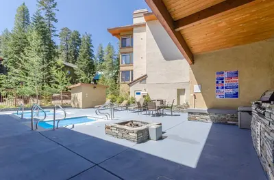a patio with a fire pit and a building at Silver Bear 18 Condo in Mammoth Lakes