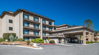 a hotel with a parking lot in front of it at Yosemite Southgate Hotel & Suites in Oakhurst