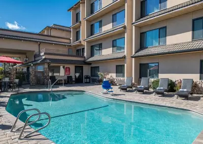 a swimming pool in front of a hotel at Yosemite Southgate Hotel & Suites in Oakhurst