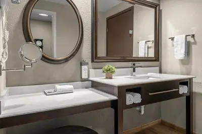 a bathroom with a sink and a mirror at Yosemite Southgate Hotel & Suites in Oakhurst