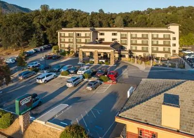 an aerial view of a parking lot in front of a building at Yosemite Southgate Hotel & Suites in Oakhurst