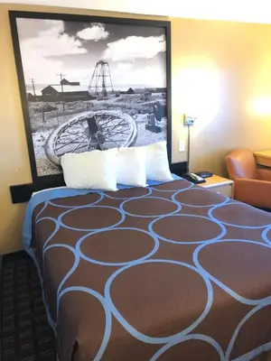 a hotel room with a bed with a large picture on the wall at Super 8 by Wyndham Carson City Lake Tahoe in Carson City