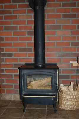a stove with a brick wall and a basket at Edelweiss Lodge in Mammoth Lakes