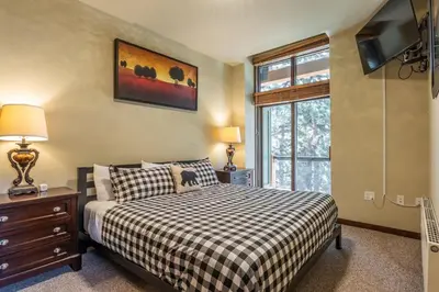 a bedroom with a bed and a tv and a window at Solstice 6 in Mammoth Lakes