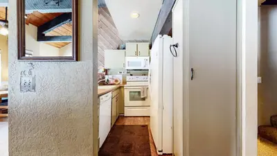 a kitchen with white cabinets and a white refrigerator at Bigwood #62 Condo in Mammoth Lakes