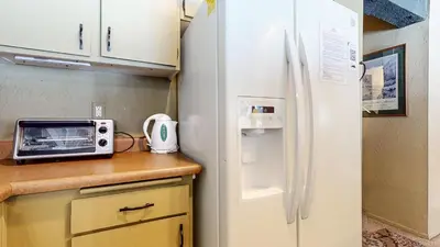 a kitchen with a white refrigerator and a microwave at Bigwood #62 Condo in Mammoth Lakes
