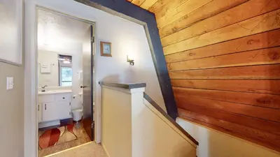 a bathroom with a wood paneled wall and a hallway at Bigwood #62 Condo in Mammoth Lakes